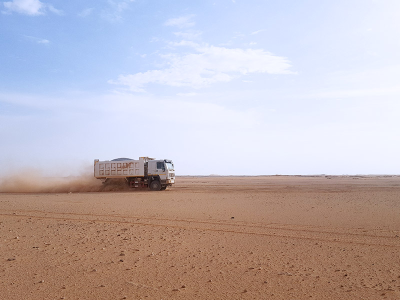 Le camion à benne roule dans le profondeur du Sahara avec une performance stable